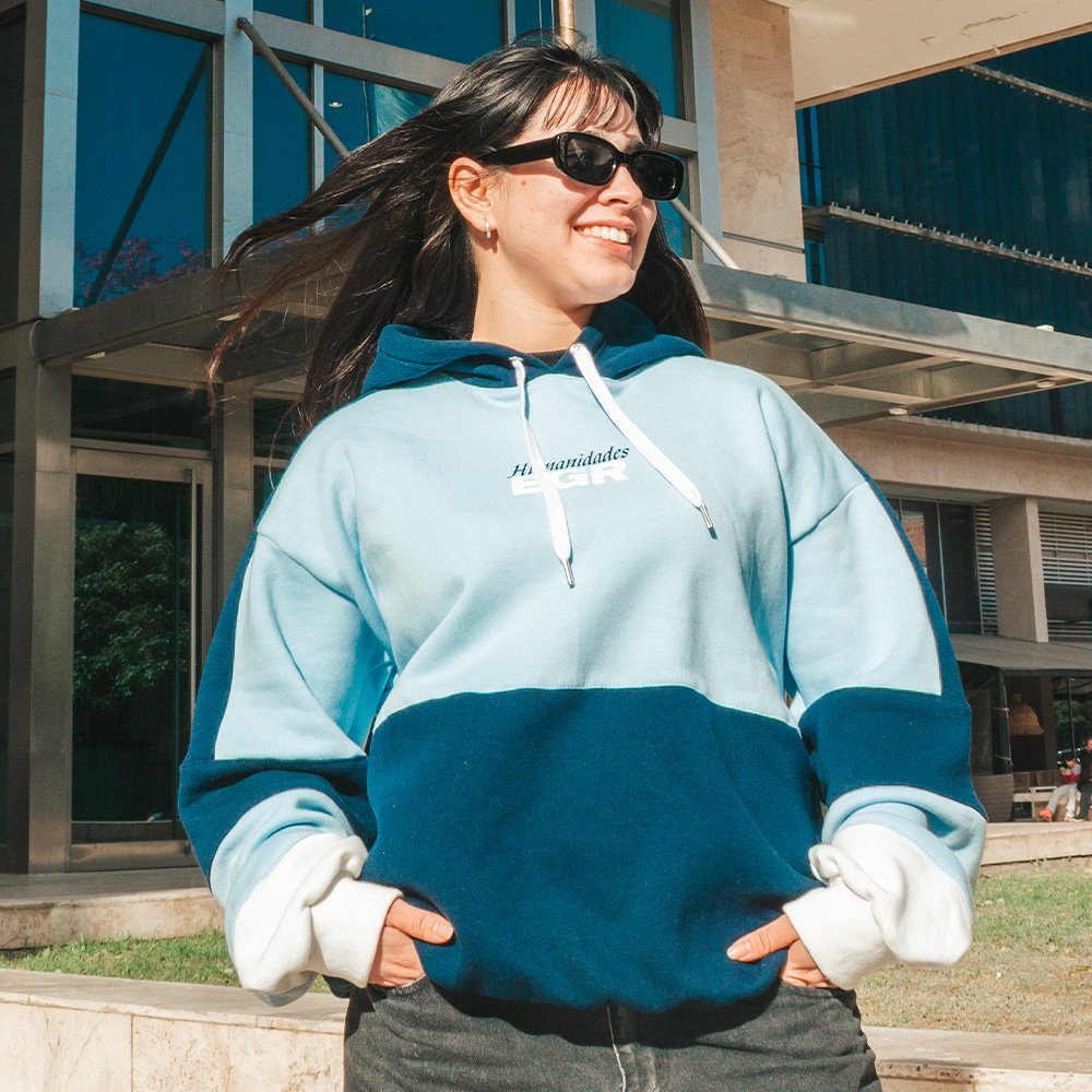 Buzo de egresados oversize en celeste y azul, con el nombre de la carrera bordado en el pecho
